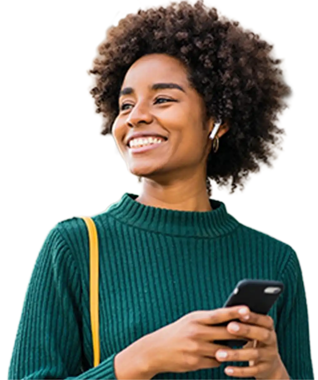 A young person holding a phone and smiling.